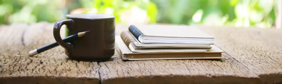 Notizbuch und Kaffeetasse – Symbol für Beratung und Kontakt zu energycare